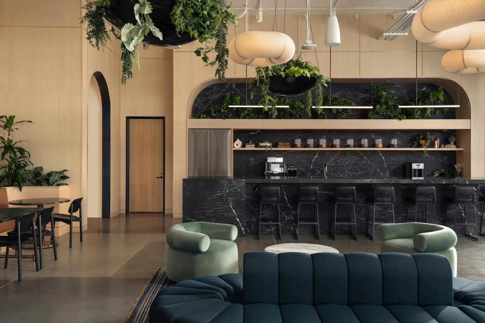 Lounge and black marble bar under a wood arch, built by Dovetail for Atmosphere TV