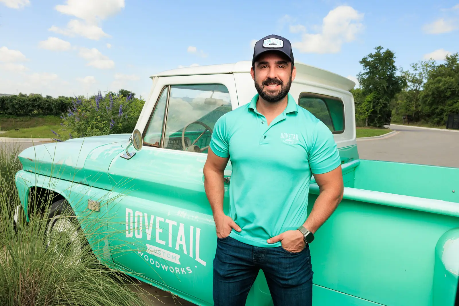 Isaac Alexander beside the teal vintage Dovetail pickup truck