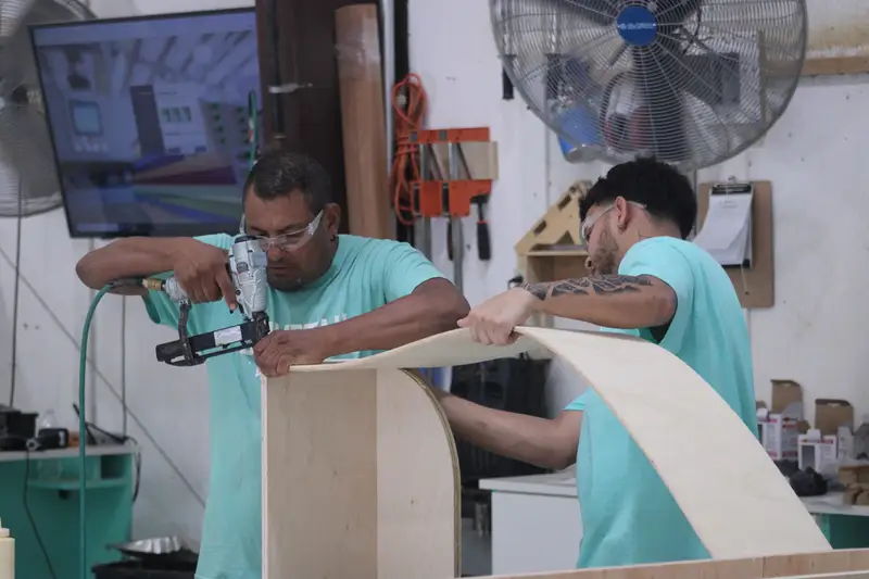 Dovetail craftsman shaping a curved wood panel