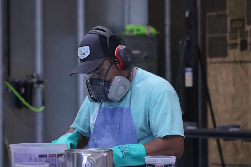 Finisher in a respirator in the Dovetail finishing booth