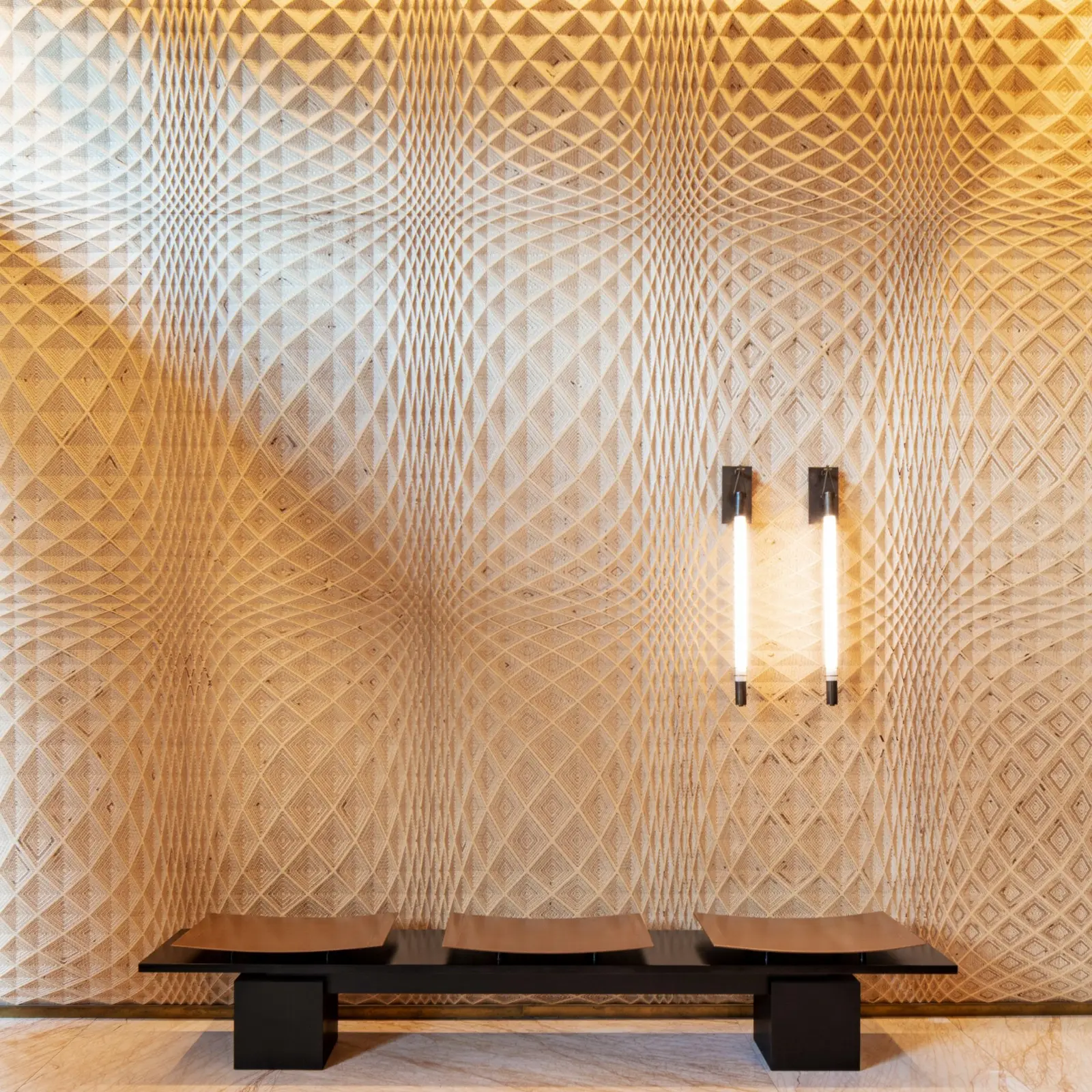 Milled wood wall with a diamond lattice pattern, two vertical lights and a bench
