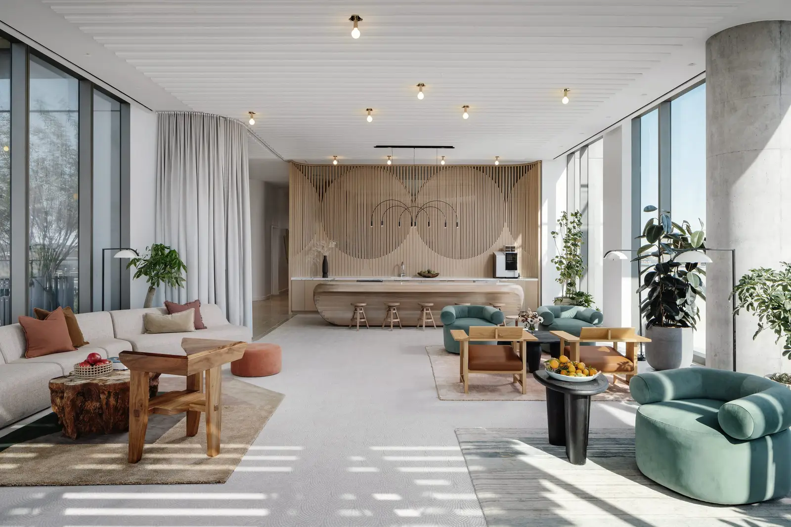 44 East amenity lounge with a wood feature wall, green chairs and floor-to-ceiling windows