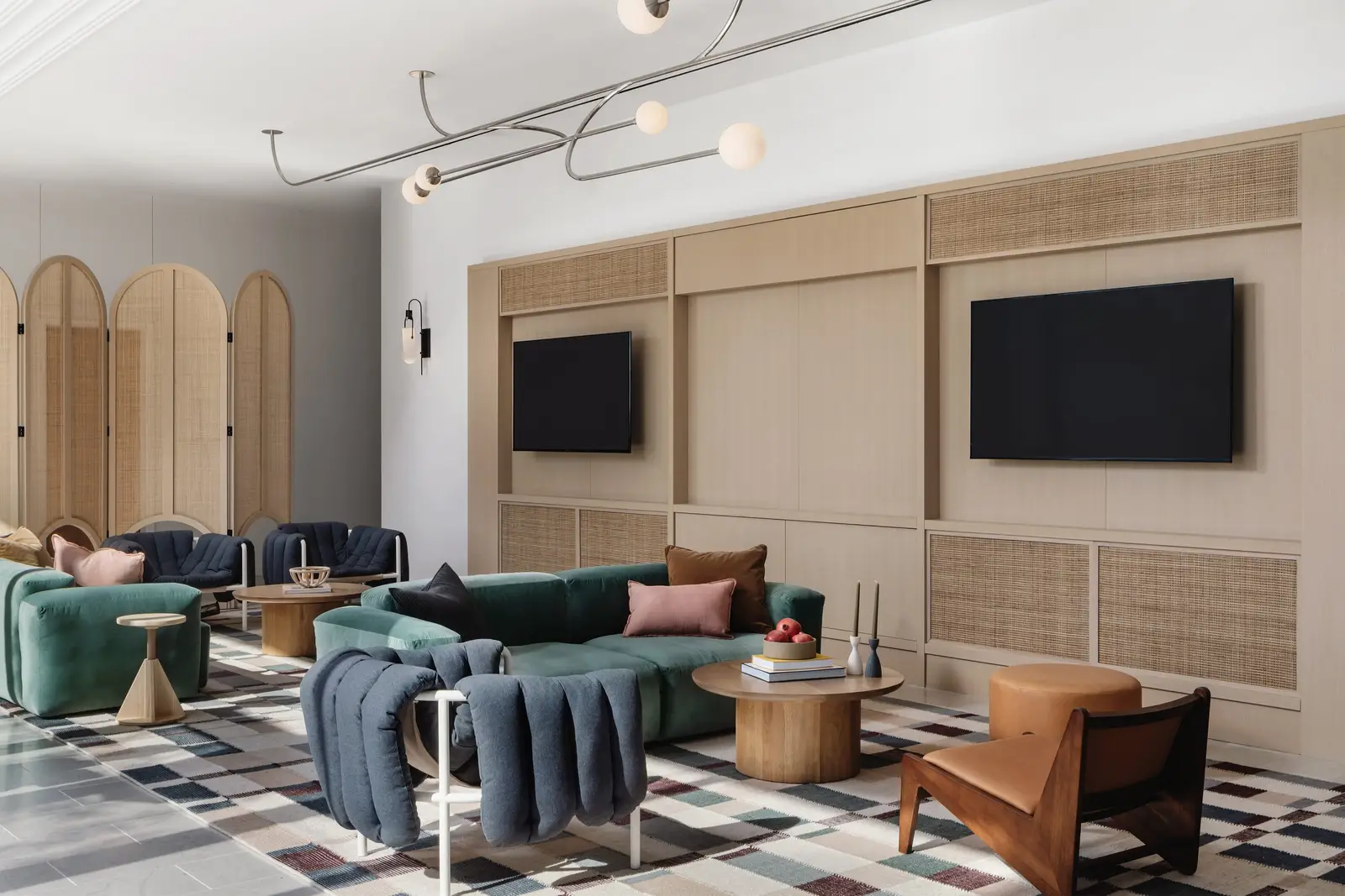 44 East lounge with arched wood panels, TVs and green and blue seating