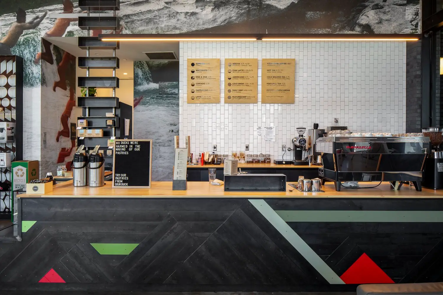 Arrive Hotel coffee bar with a patterned counter front and white tile wall