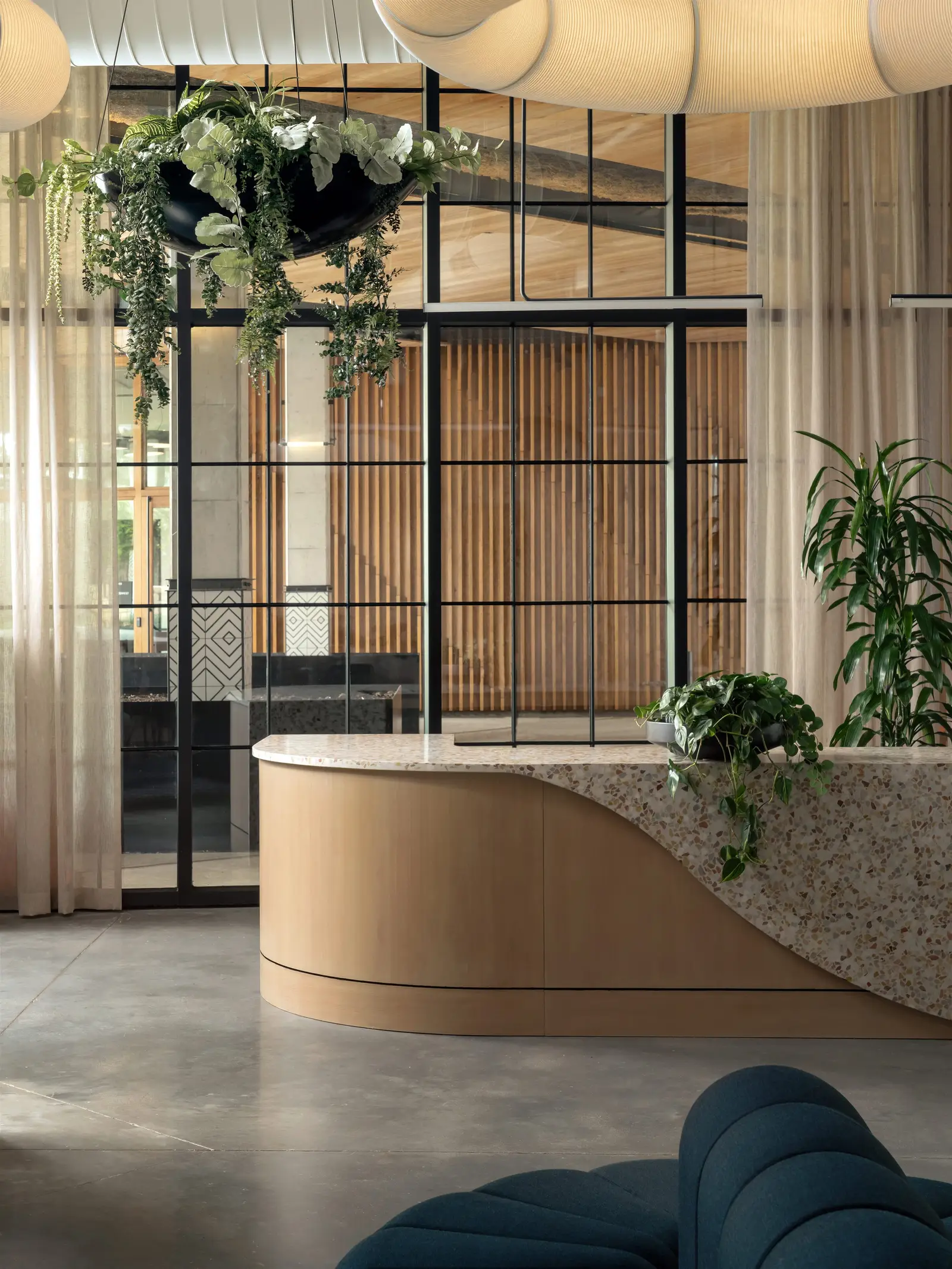 Atmosphere TV reception desk with a curved wood front and a speckled stone top