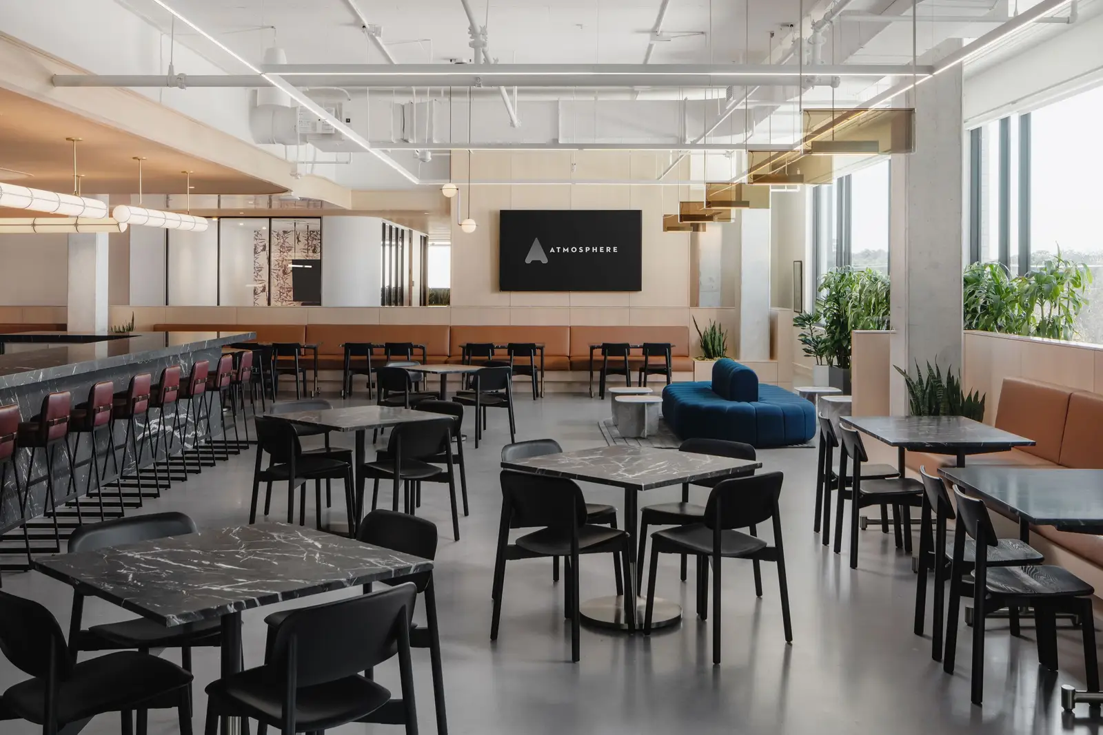Atmosphere TV open cafeteria with black tables and chairs and a long bar