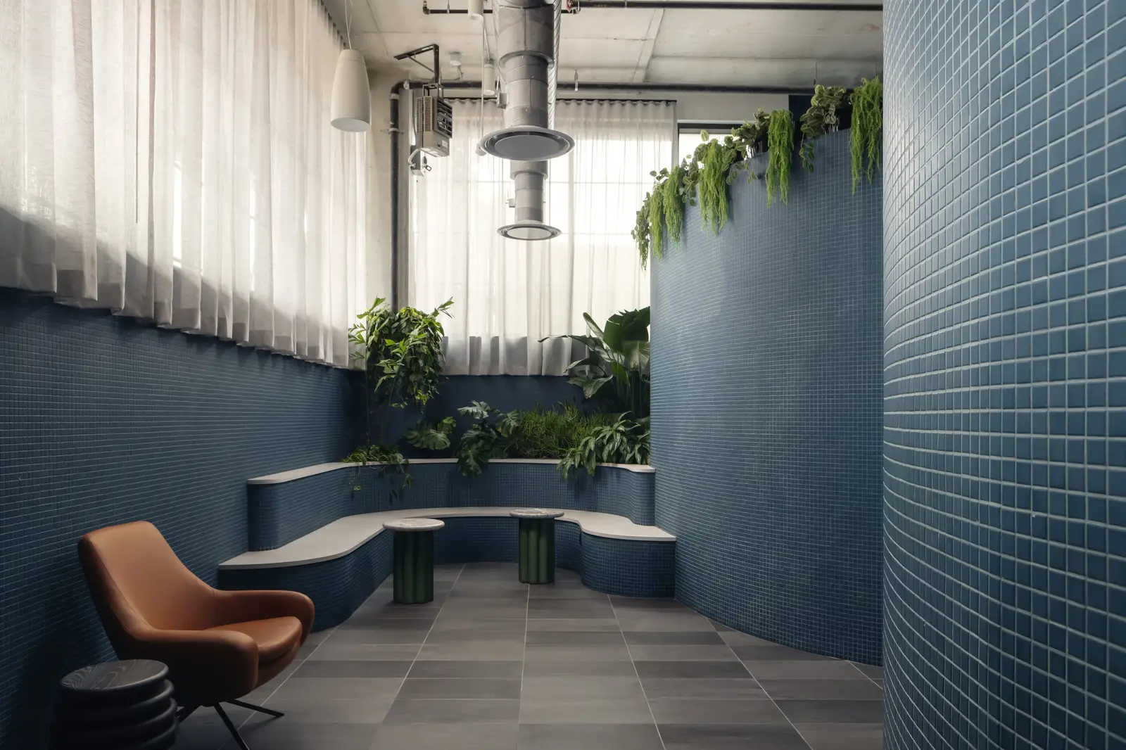 Atmosphere TV tiled blue seating nook with a curved wall and plants