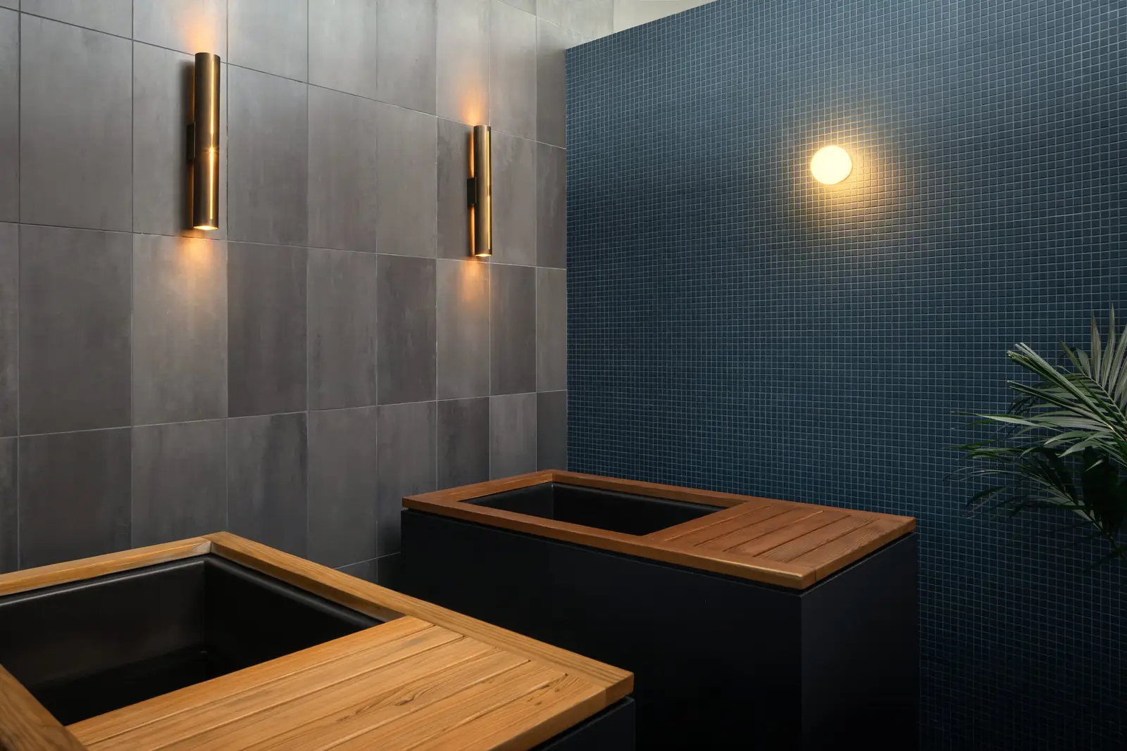 Atmosphere TV wellness room with two dark wood-topped tubs against blue tile