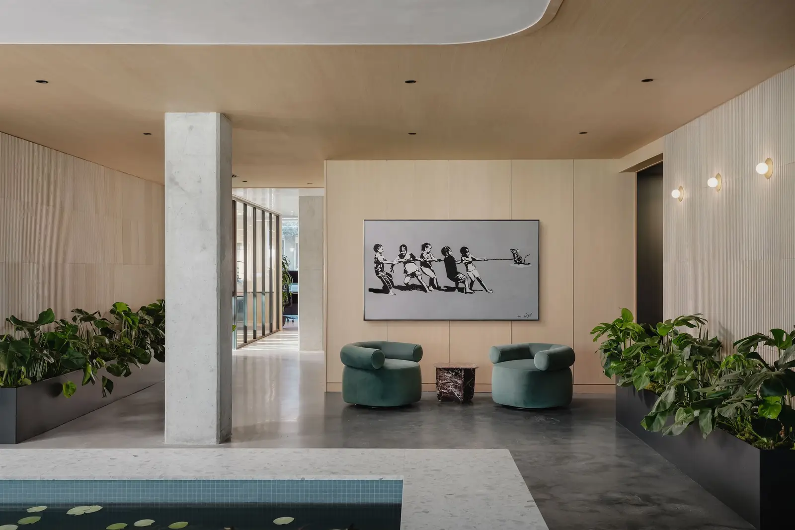 Atmosphere TV office entry with a wood ceiling soffit, planters and framed artwork
