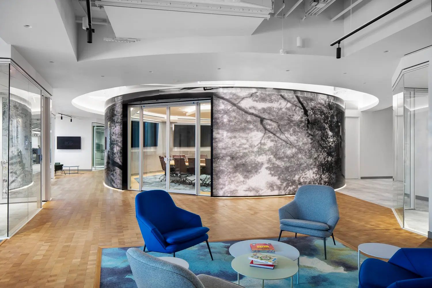 Boston Consulting Group office lounge with a round clad conference room and blue chairs