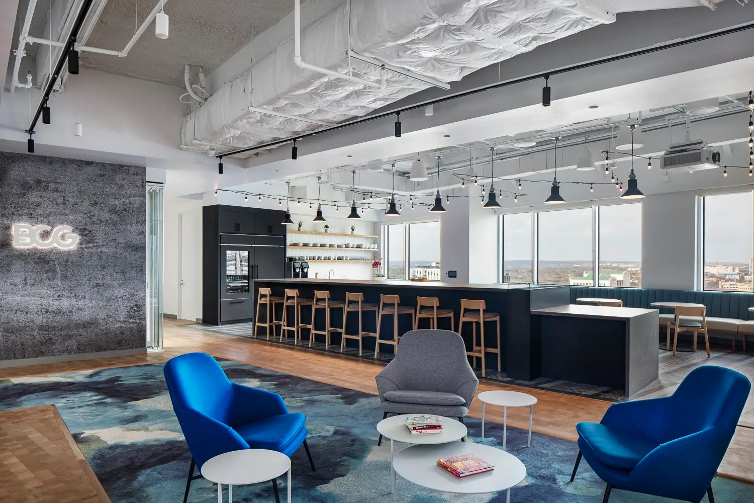 Boston Consulting Group open pantry area with bar seating and a logo wall