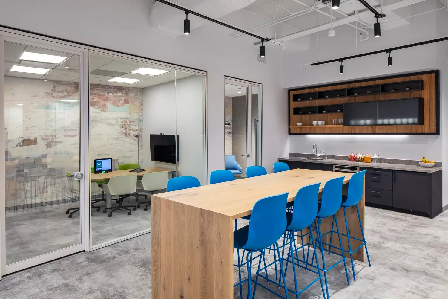 Boston Consulting Group meeting area with a wood table, blue stools and a built-in cabinet