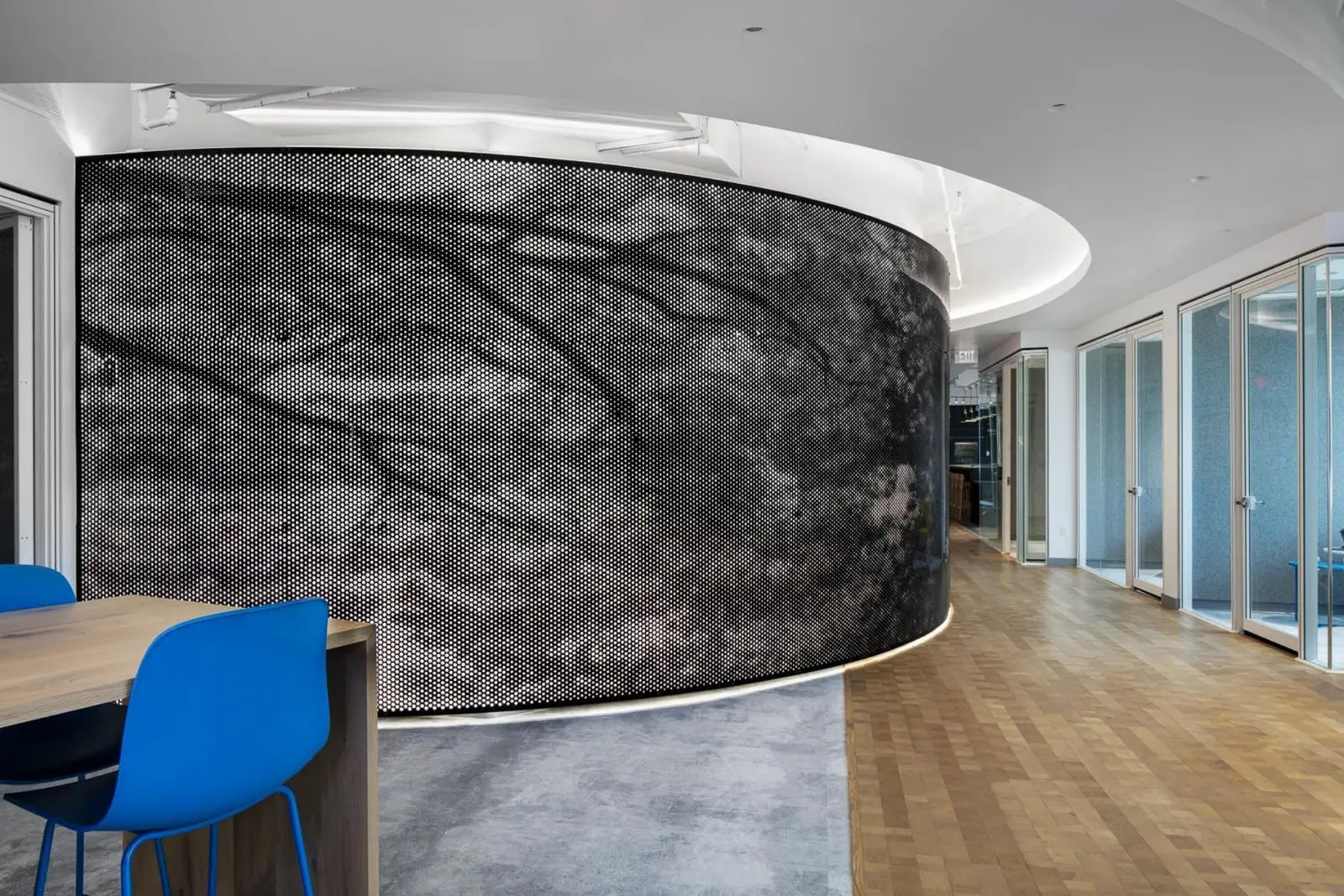 Boston Consulting Group curved patterned wall beside a blue chair and a wood counter