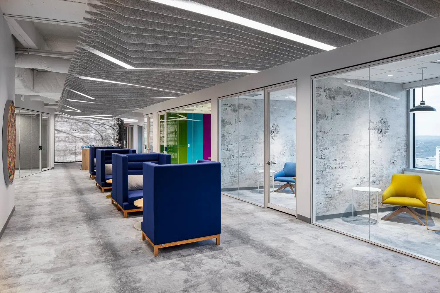Boston Consulting Group corridor with blue lounge chairs and glass-walled rooms
