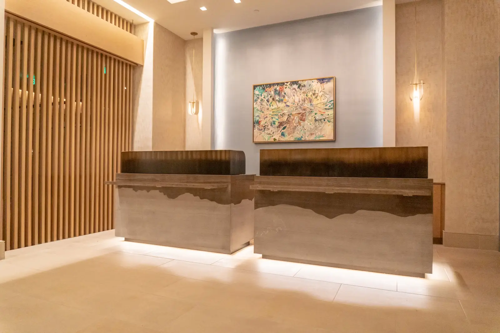 Four Seasons Hotel front desk with two stone and wood counters in front of a wood slat wall
