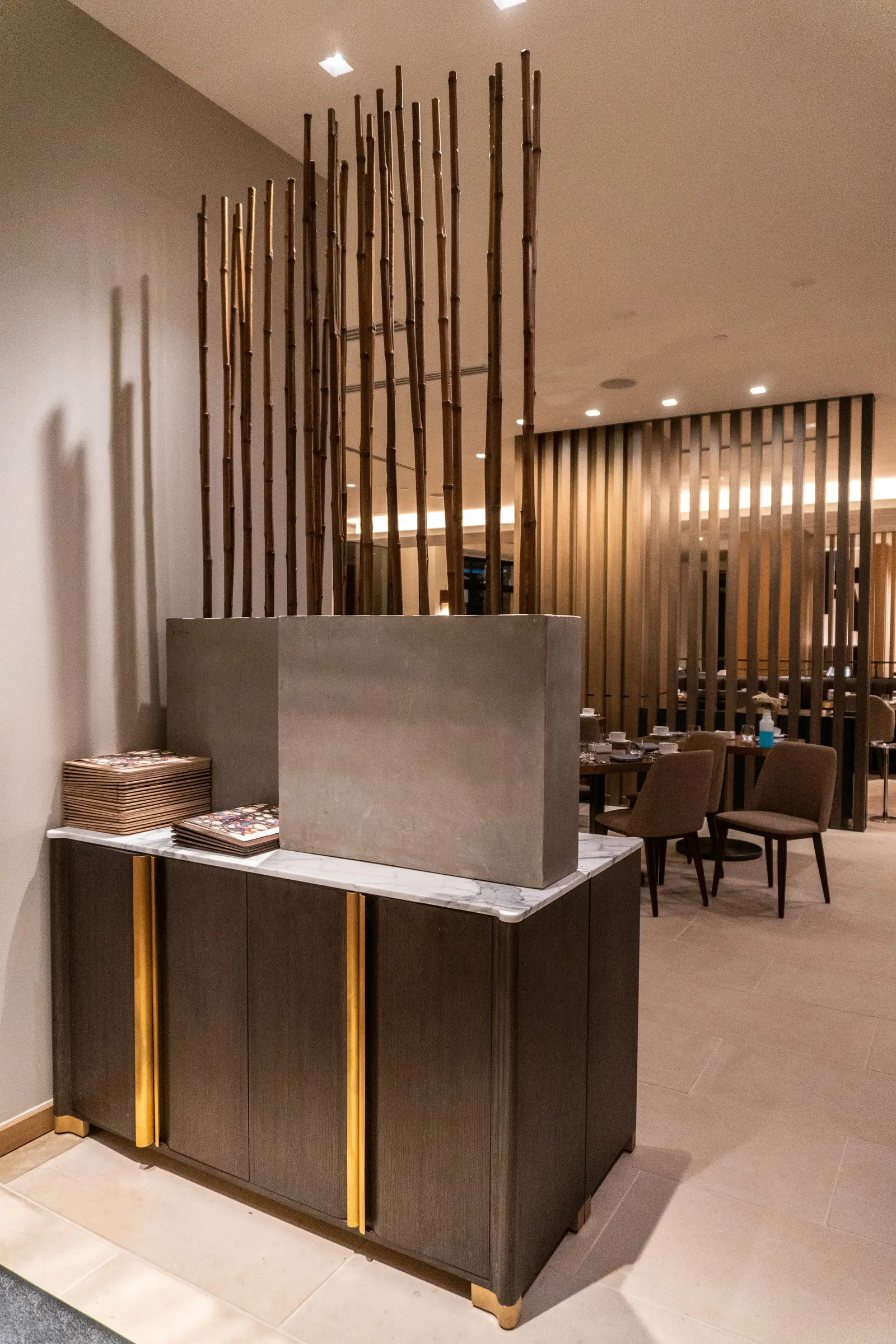 Four Seasons Hotel host stand with a metal and stone top in front of wood slat dividers
