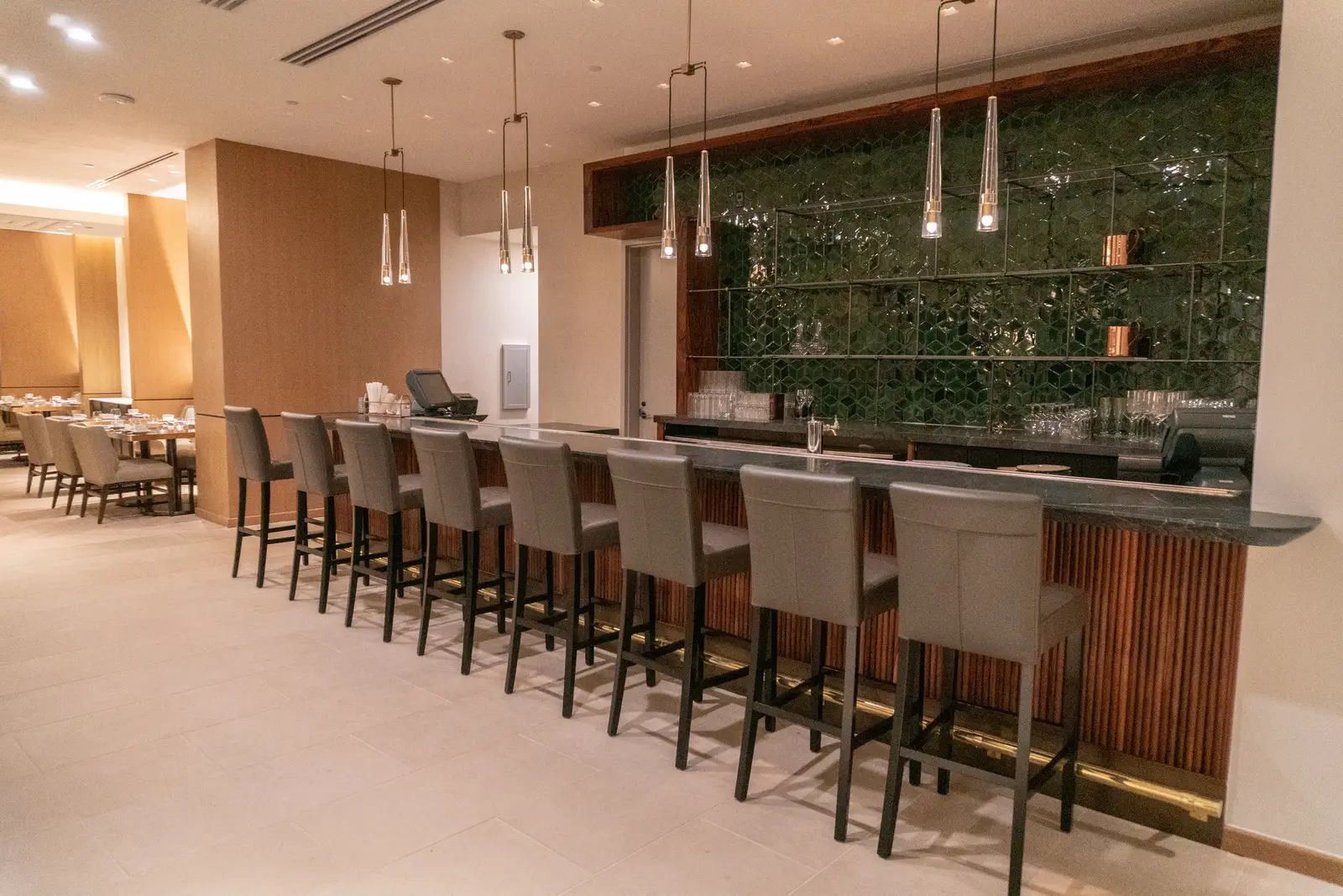 Four Seasons Hotel long bar with stools and a green backsplash