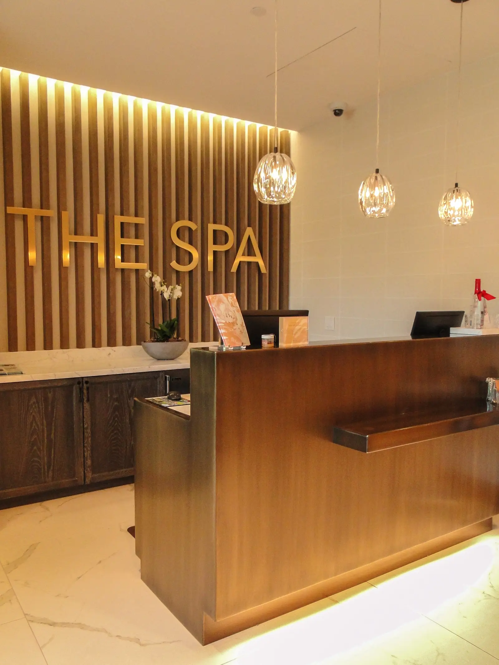 Four Seasons Hotel spa reception with a THE SPA sign on a slatted wall