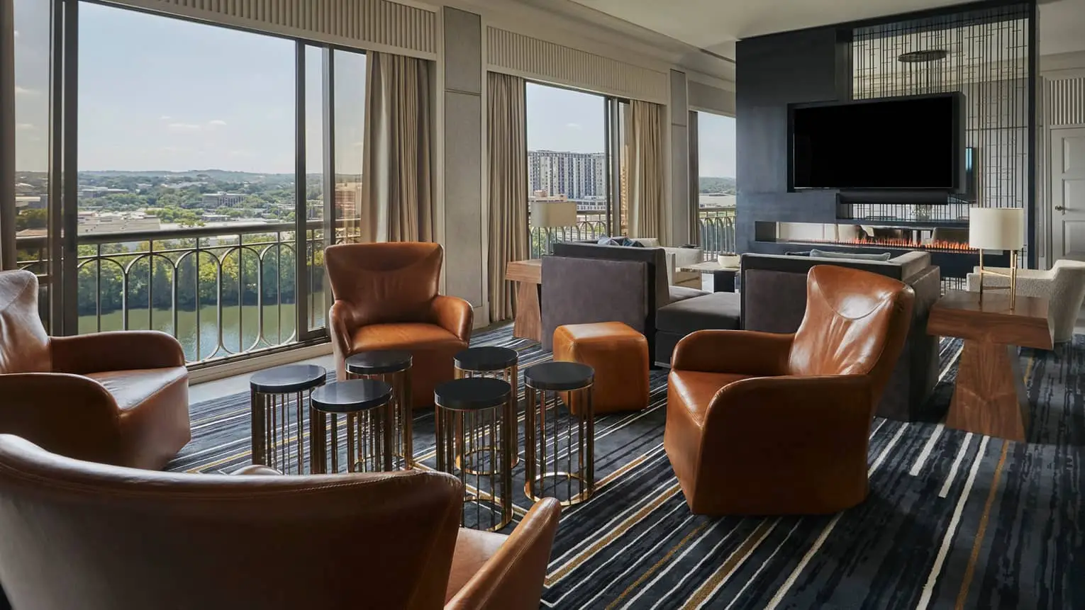 Four Seasons Hotel suite sitting room with leather chairs and a view through tall windows