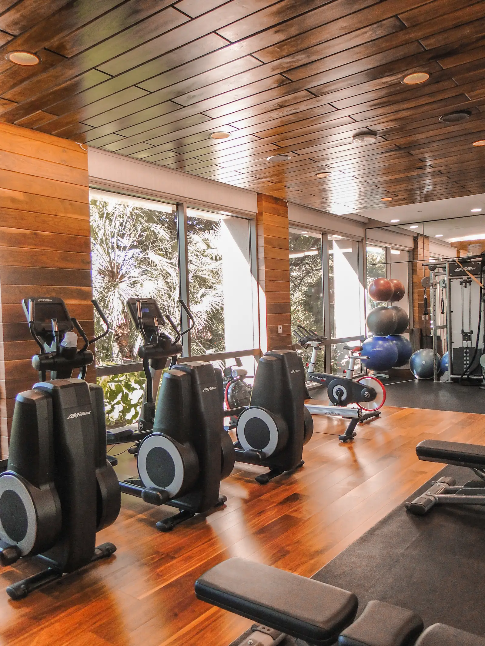 Four Seasons Hotel fitness room with a wood plank ceiling, cardio machines and floor-to-ceiling windows