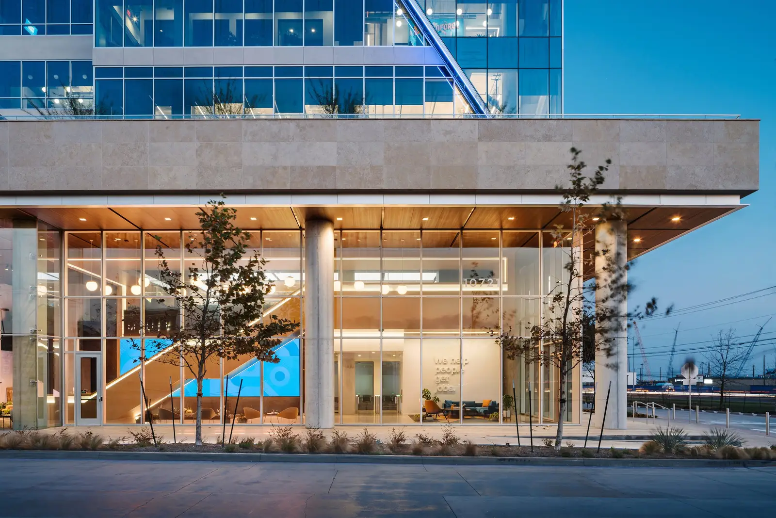 Indeed office building entrance with a stone canopy and glass at dusk