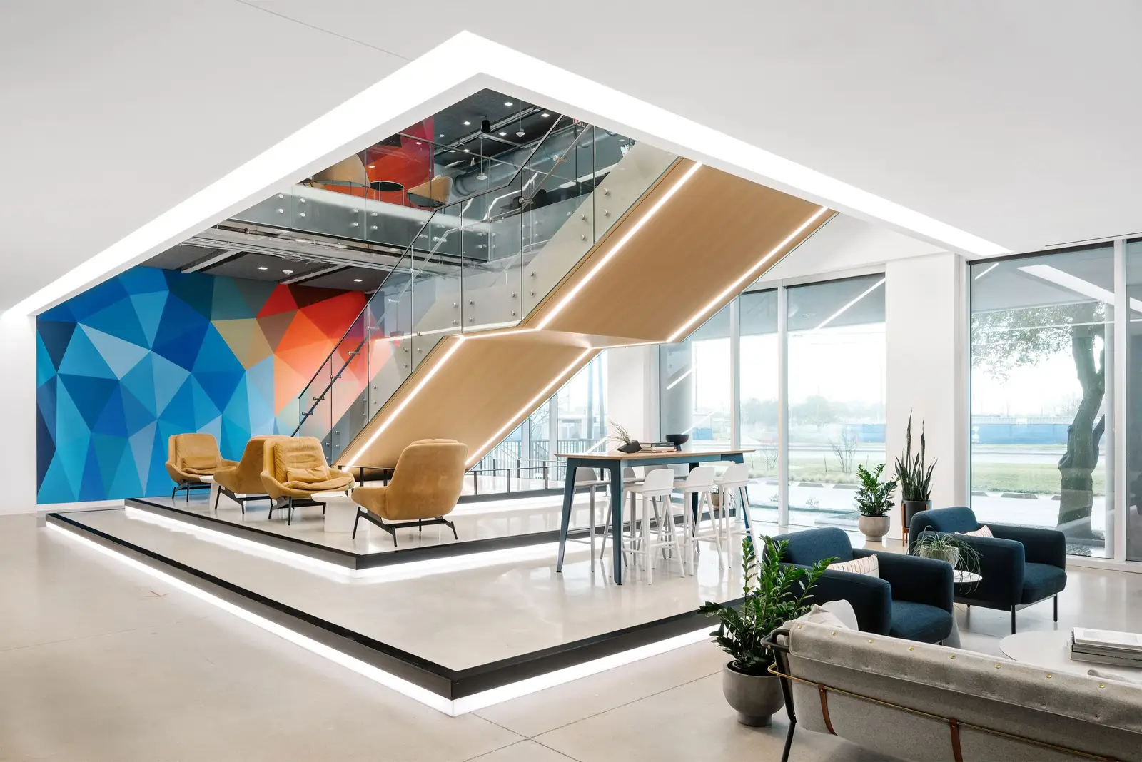 Indeed lobby with a floating stair, a blue geometric wall and wood trim