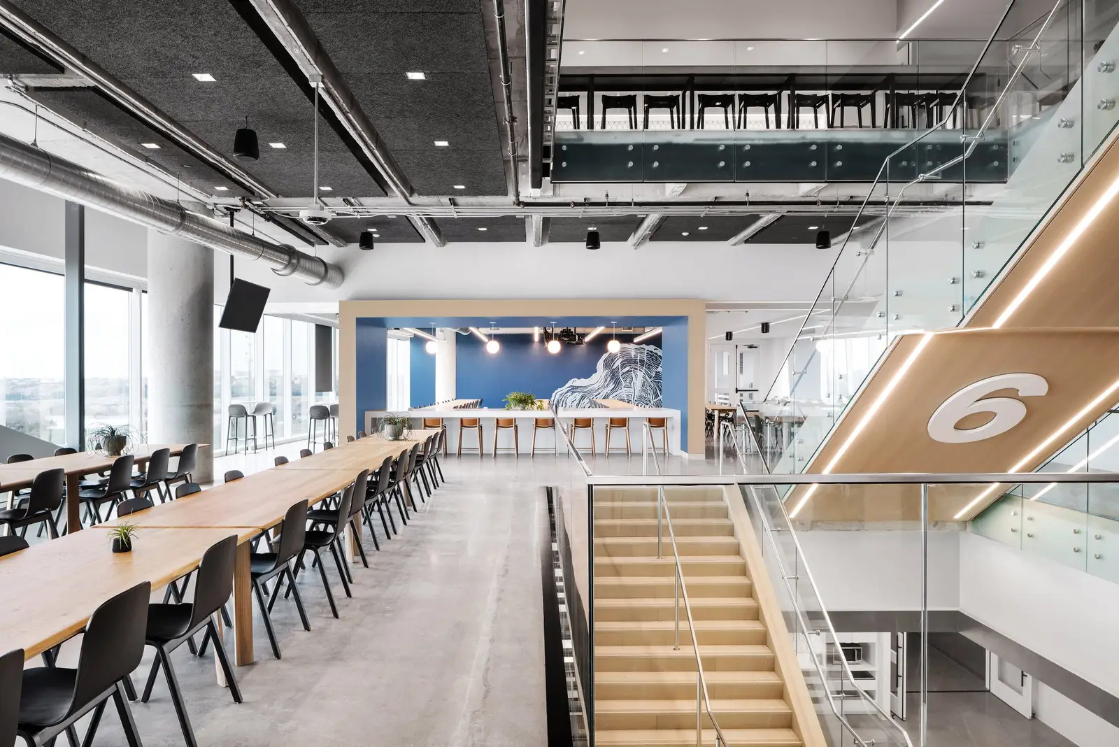 Indeed long wood tables beneath a wood stair marked with the number 6