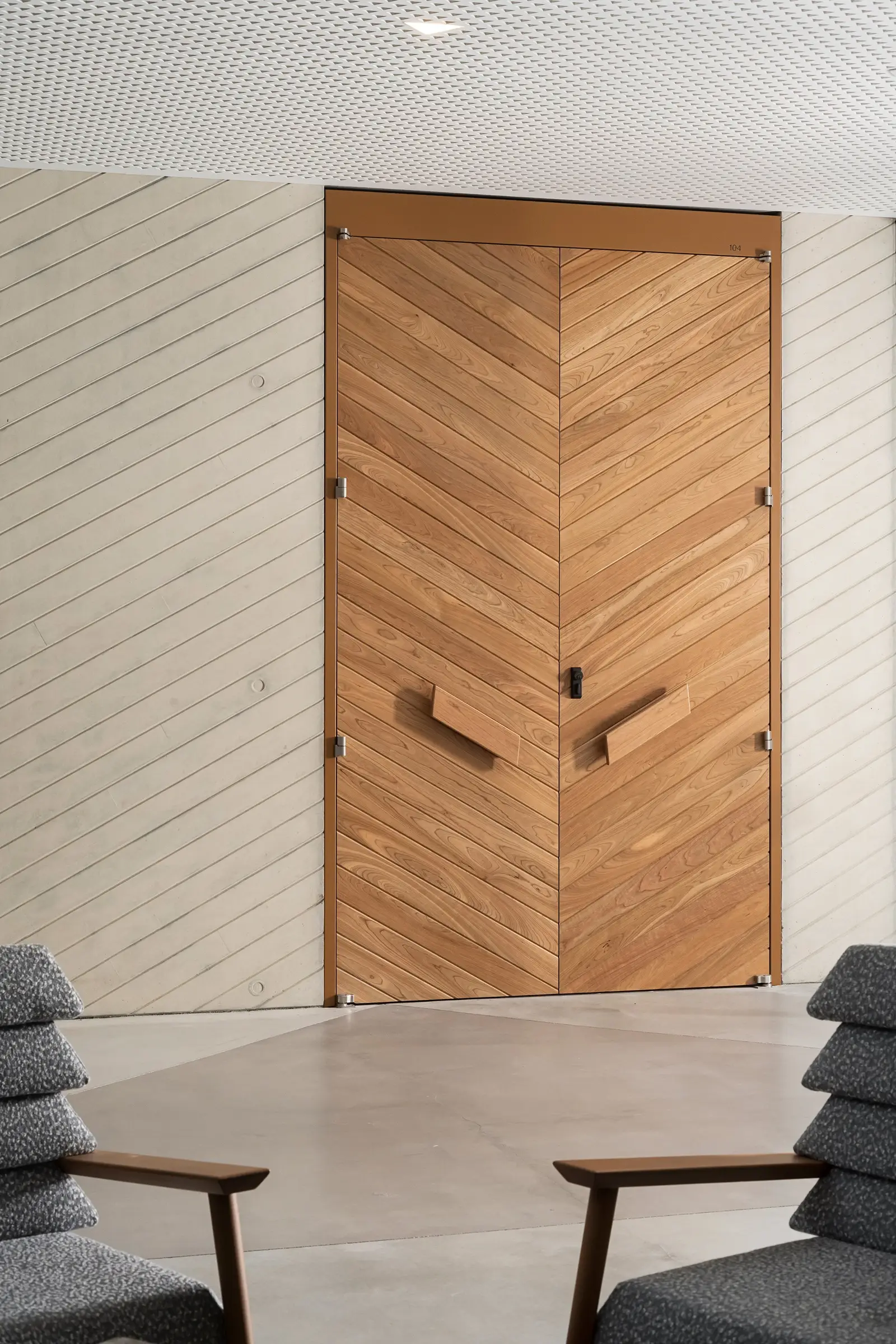 Ismaili Centre tall chevron-pattern wood door with wood pulls