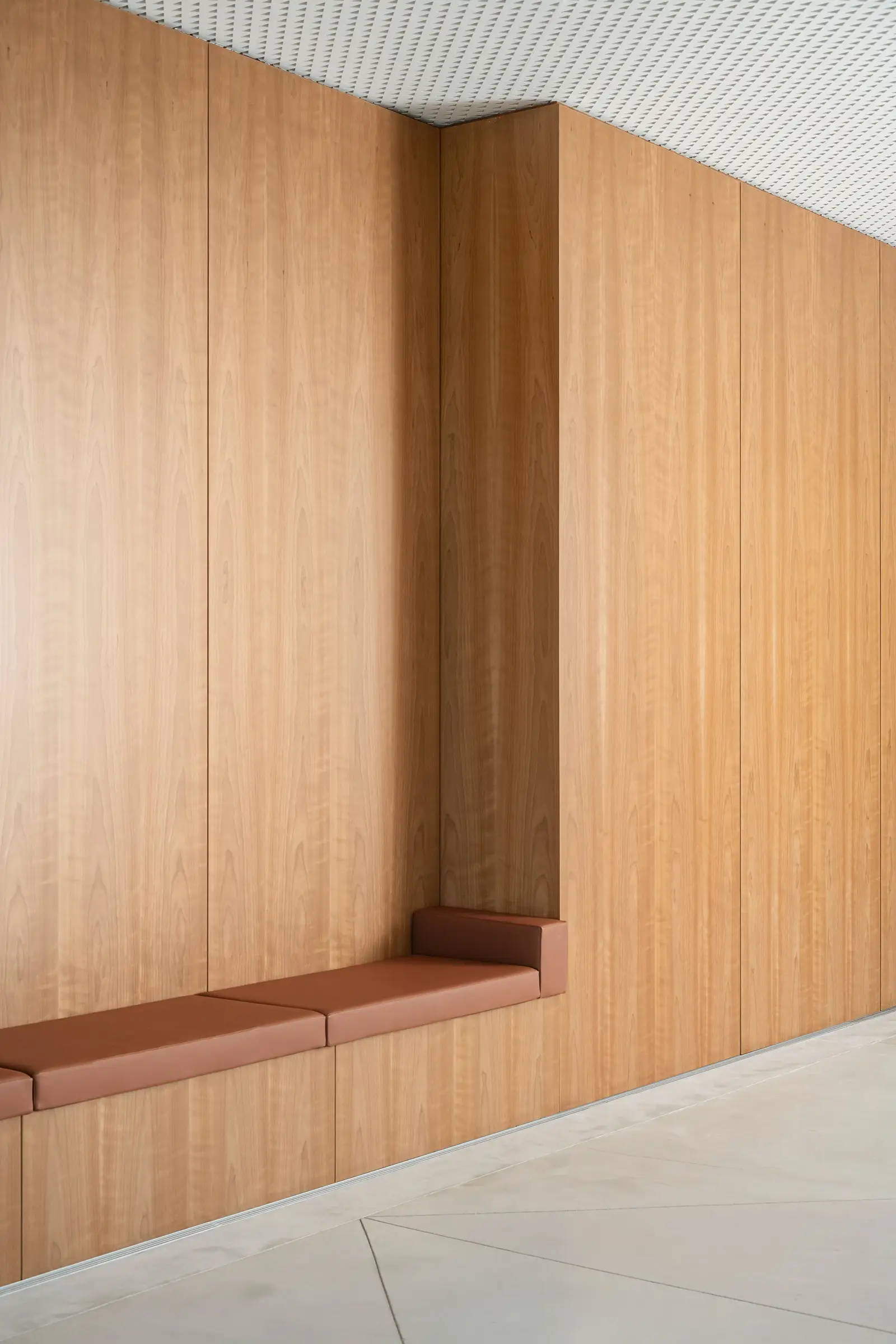 Ismaili Centre wood-paneled wall with a built-in cushioned bench niche