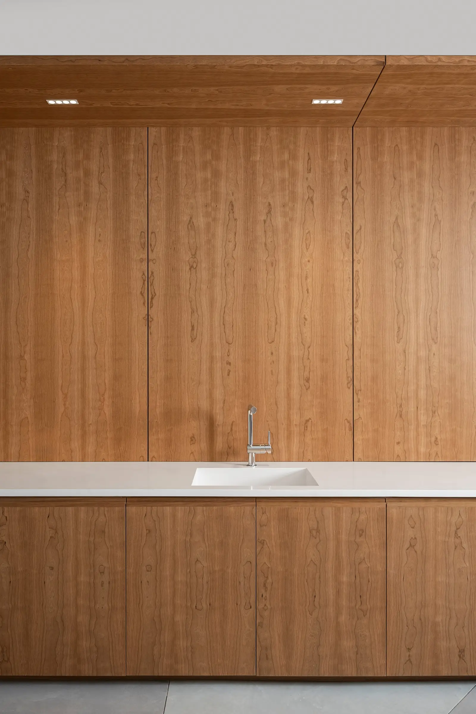 Ismaili Centre wood-paneled wall above a wood counter with a white top and sink