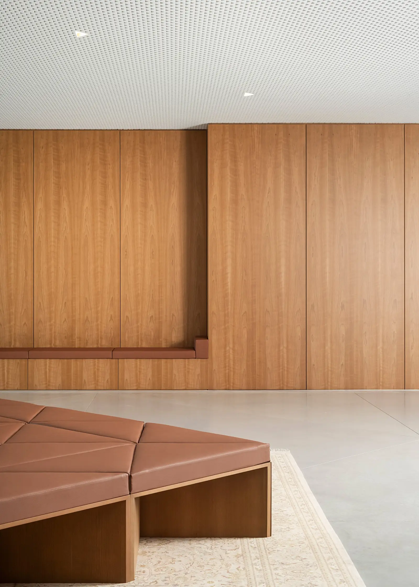 Ismaili Centre wood wall with cushioned bench units on a rug