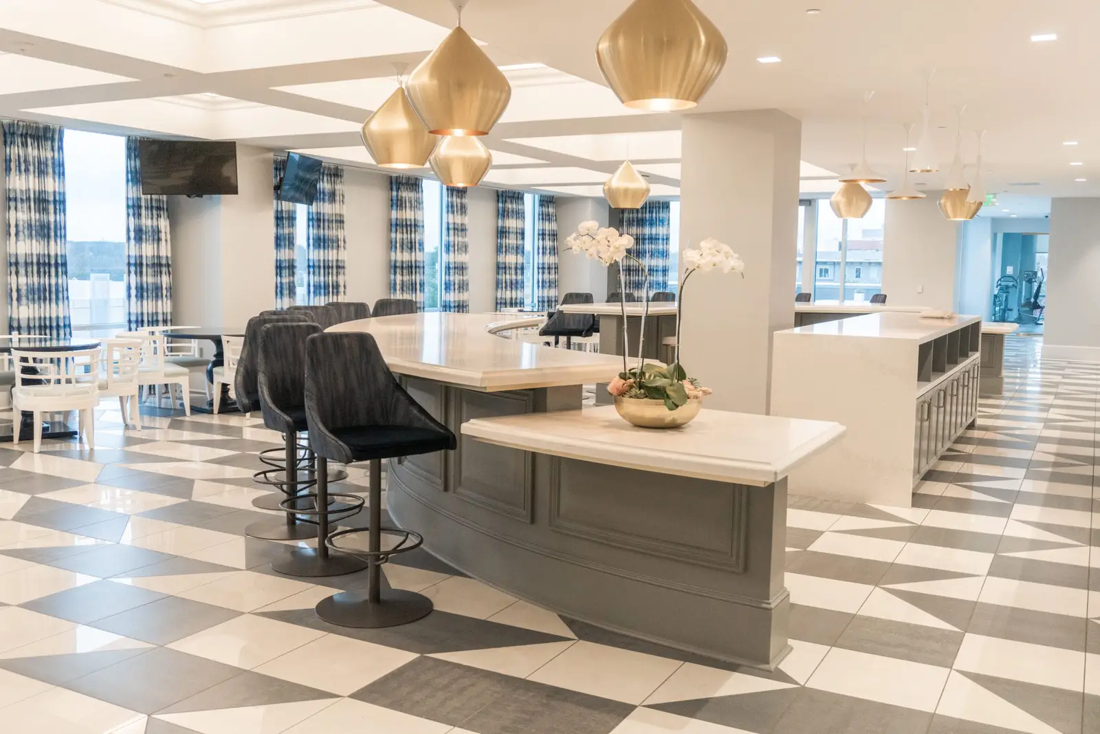 Kendra Scott break area with a checkered floor, a high island and gold pendant lights