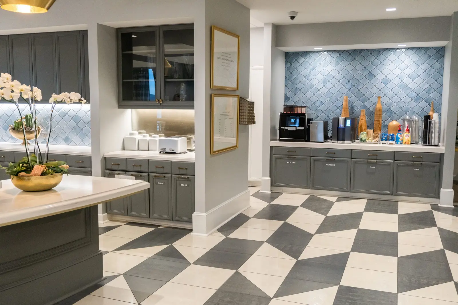 Kendra Scott pantry with gray cabinets, a blue tile backsplash and a checkered floor