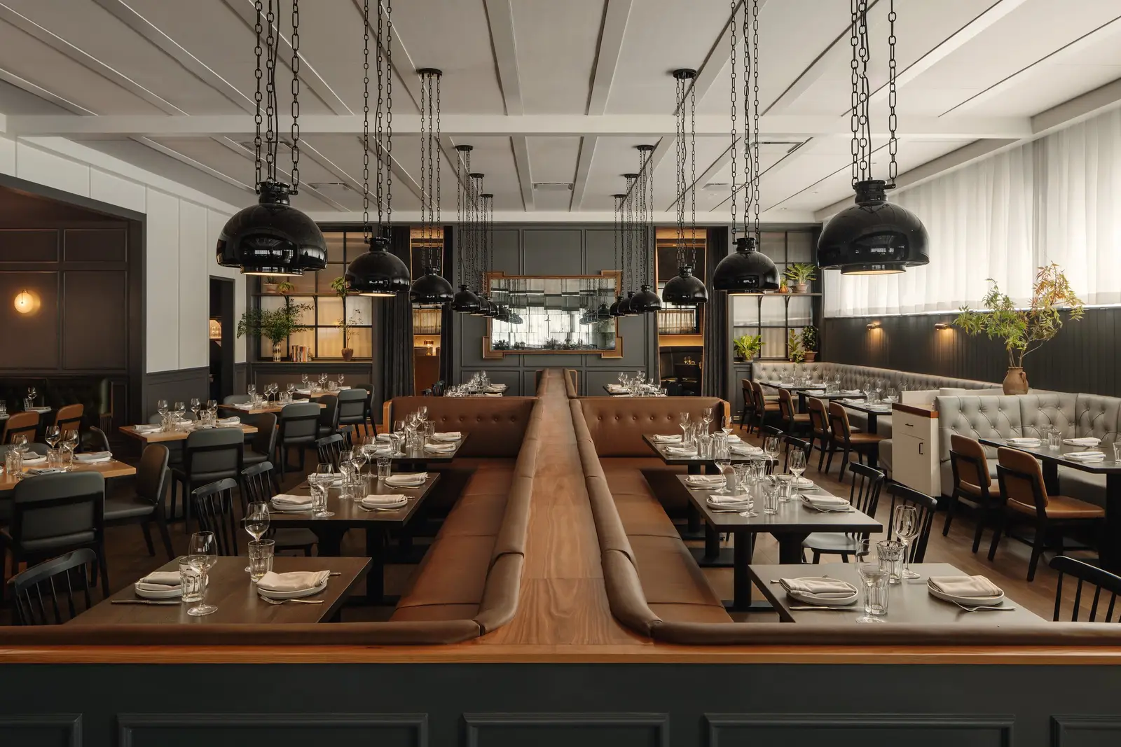 The Kitchen Bistro dining room with leather booths and pendant lights under a coffered ceiling