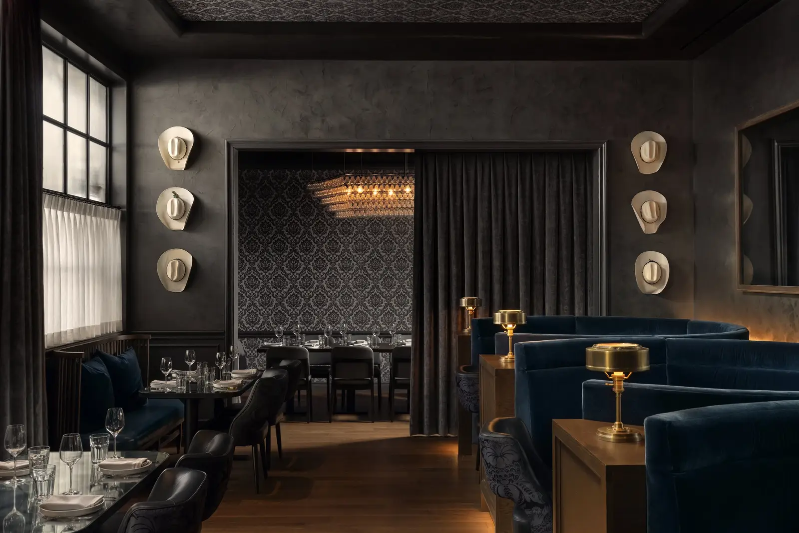 The Kitchen Bistro dark dining room with blue velvet booths and wall sconces
