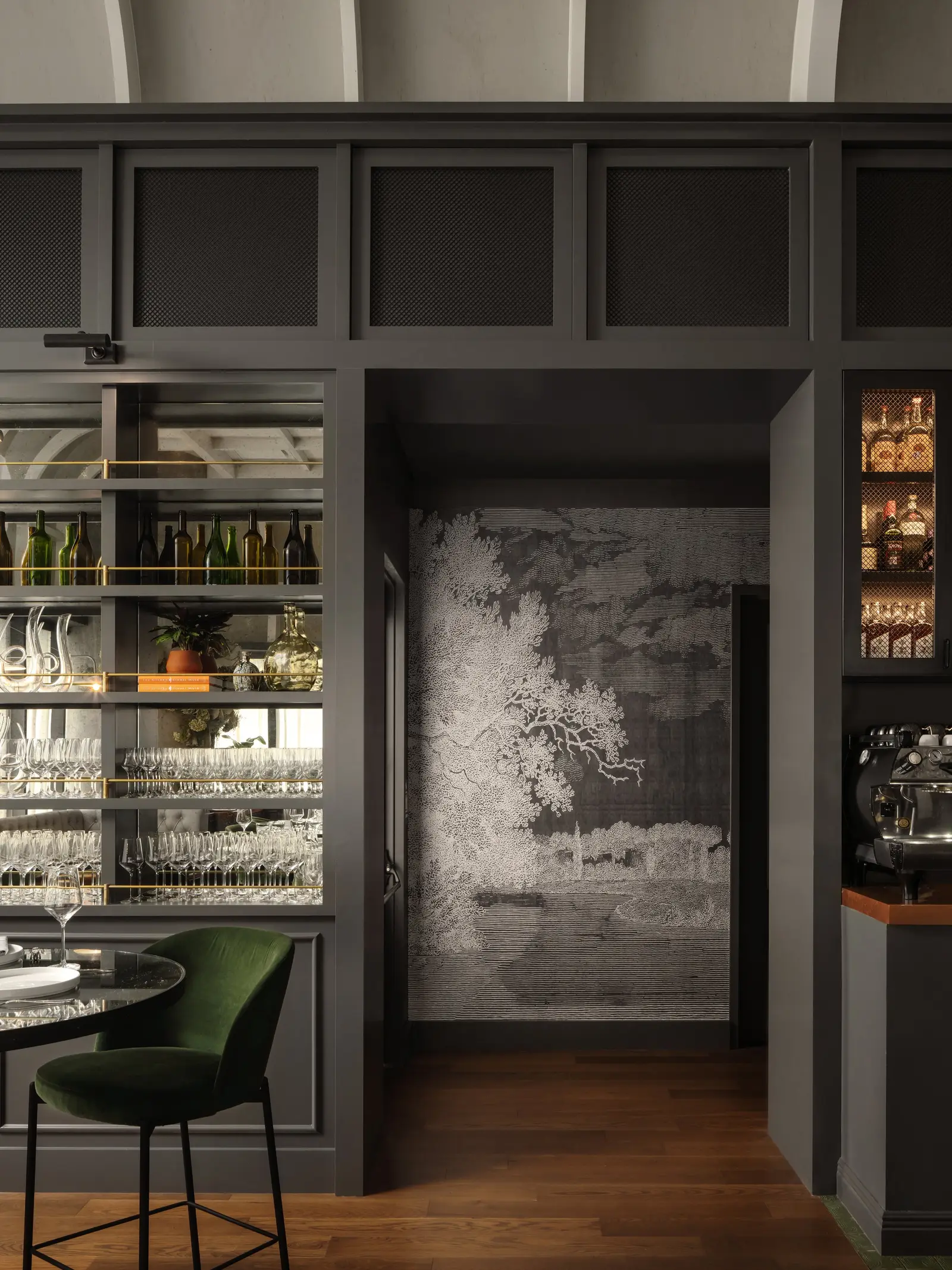 The Kitchen Bistro hallway entry beside lit back-bar glassware shelving