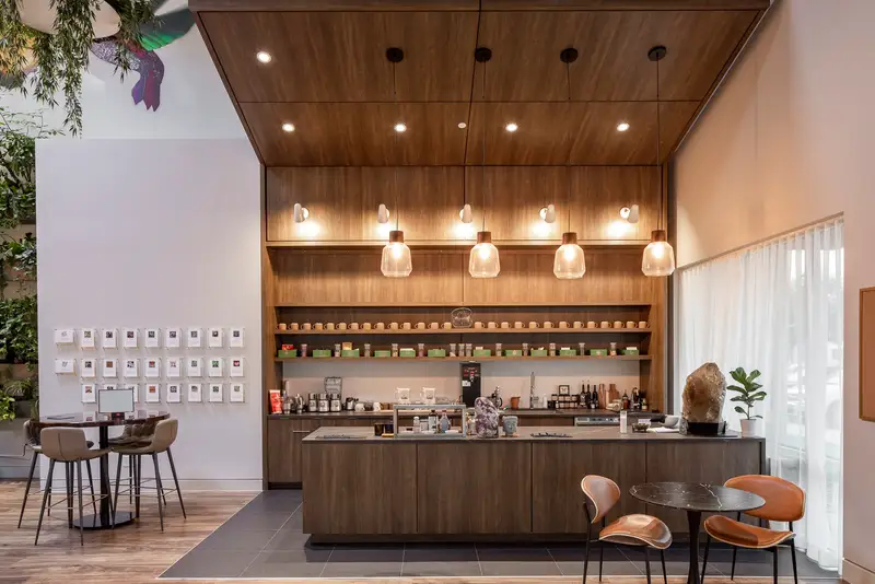 Kuya Wellness cafe counter with a wood ceiling, pendant lights and shelves