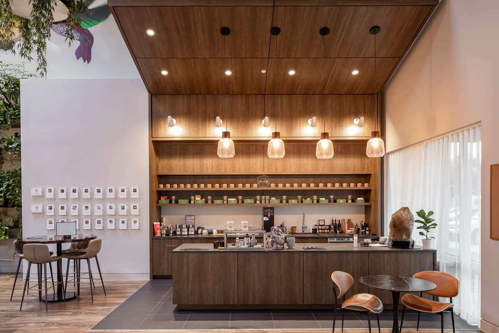 Kuya Wellness cafe counter with a wood ceiling, pendant lights and shelves