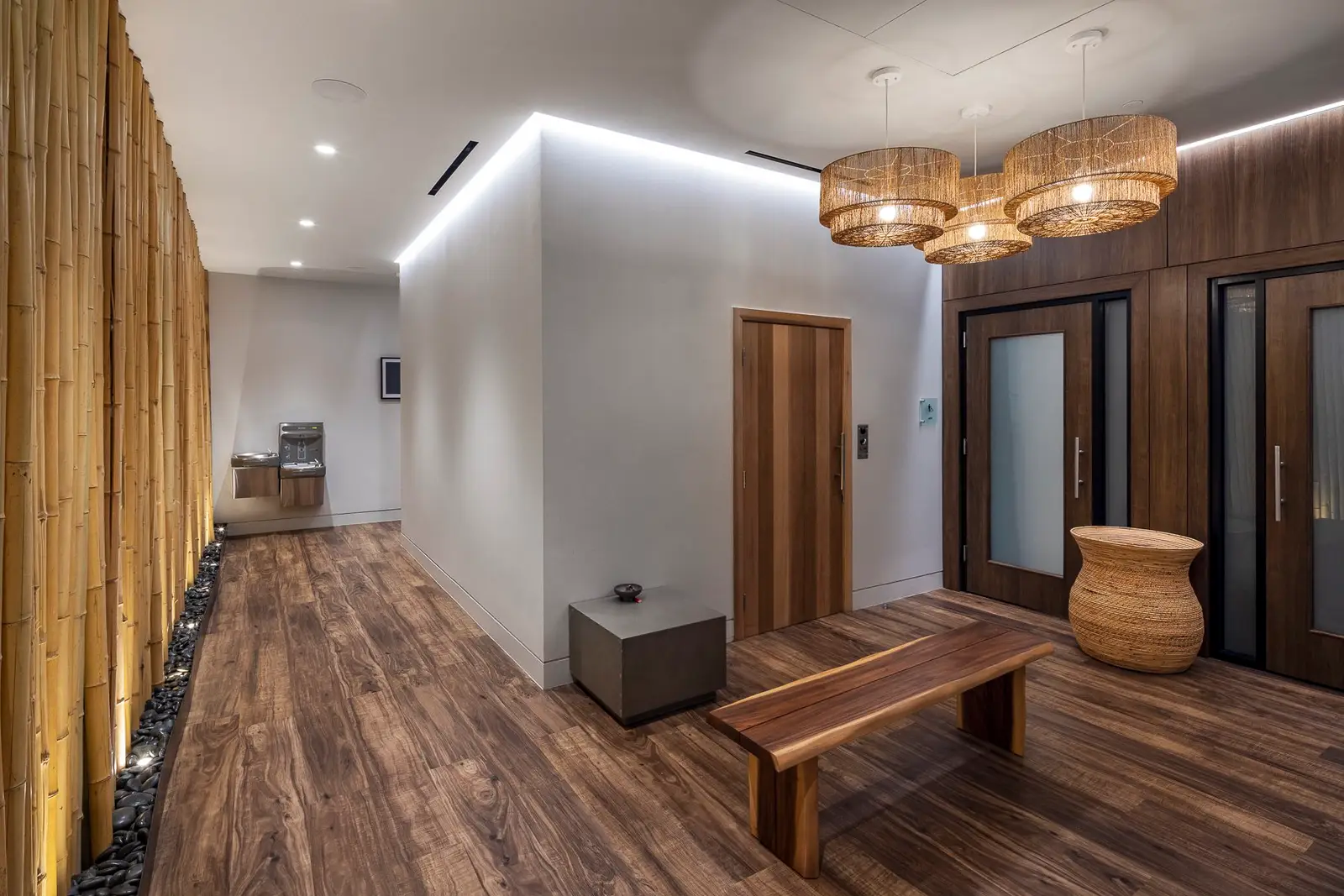 Kuya Wellness hallway with wood plank flooring, a wood bench and a wood slat wall