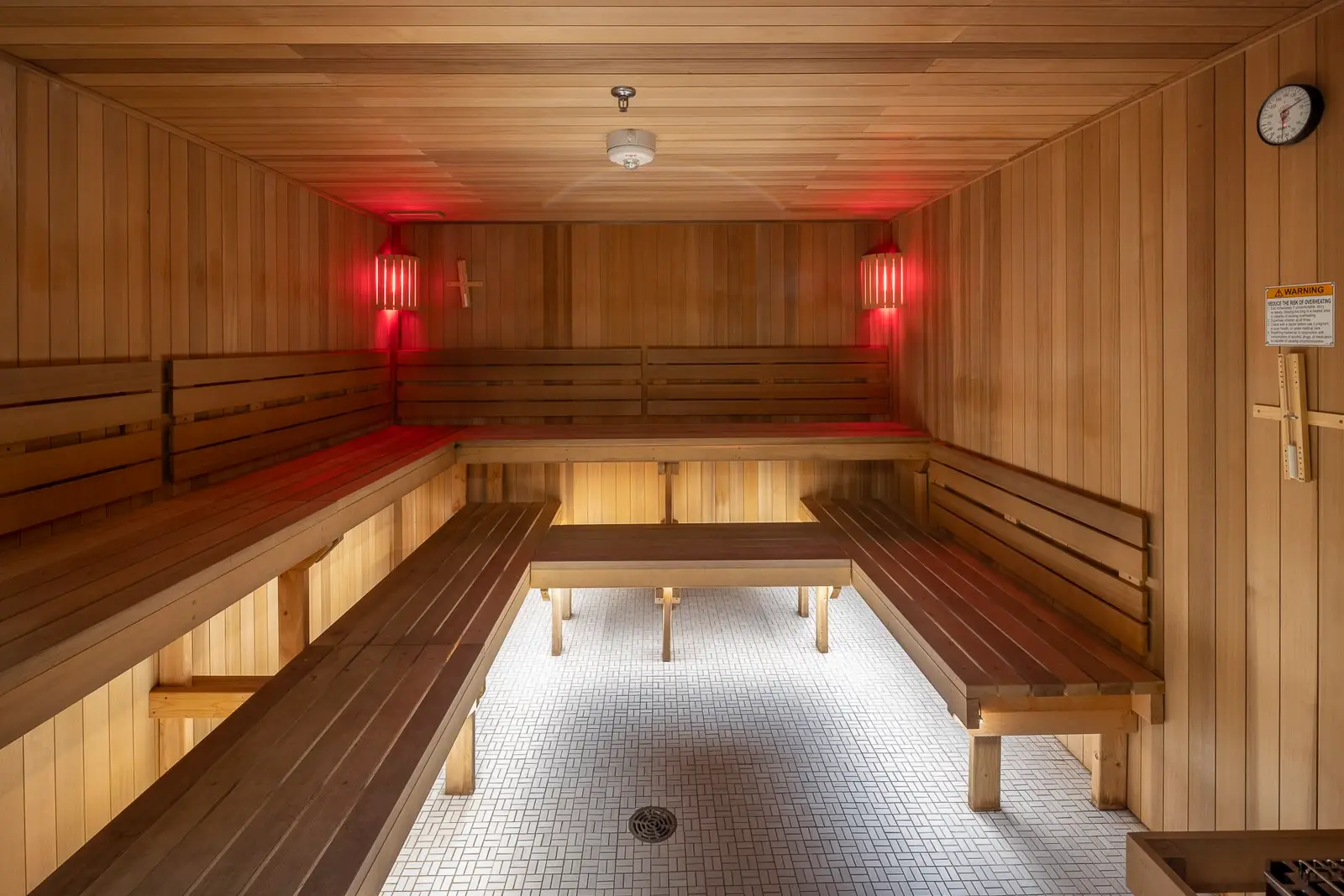 Kuya Wellness sauna with wood benches and a red-lit ceiling