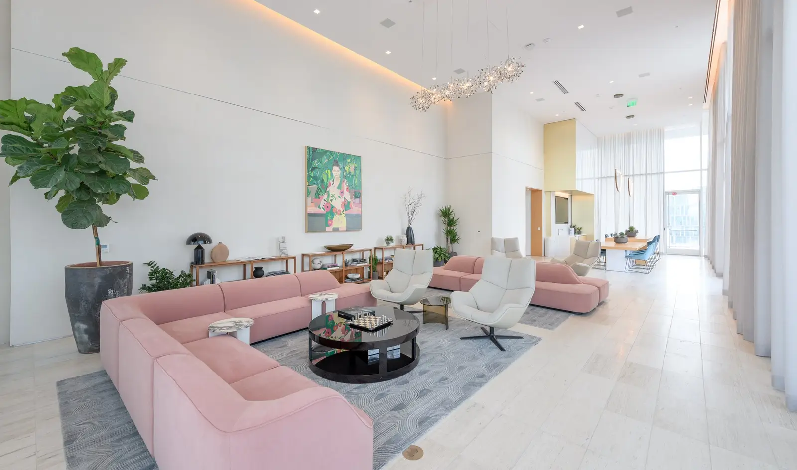 Linden Residences amenity lounge with pink sofas, pendant lights and tall windows