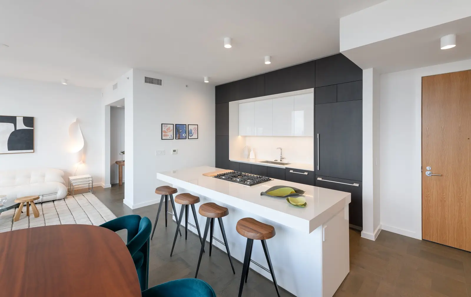 Linden Residences residential kitchen with a white island, dark cabinet wall and bar stools