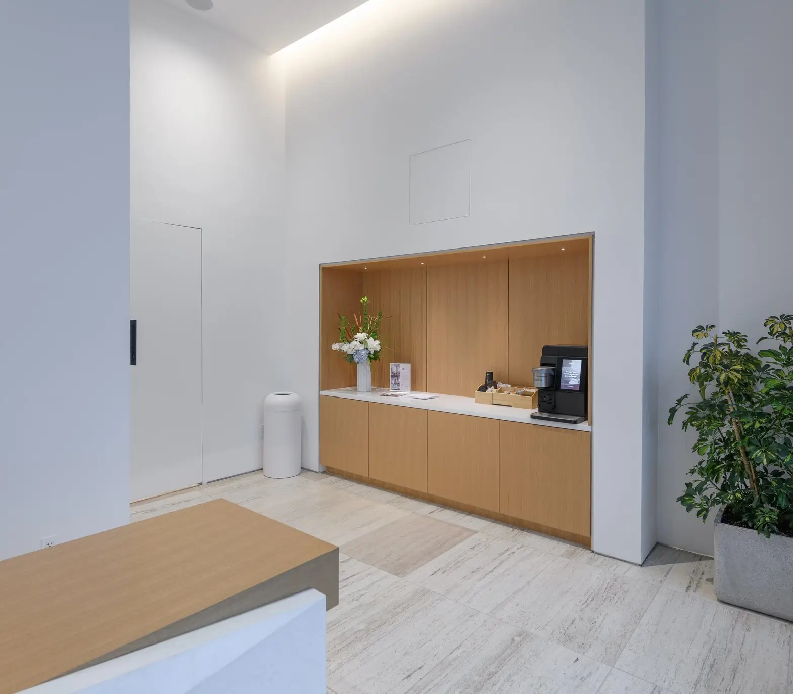 Linden Residences coffee station niche with wood cabinets in a white room
