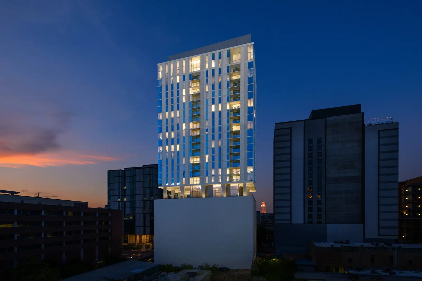 Linden Residences residential tower at dusk with lit windows