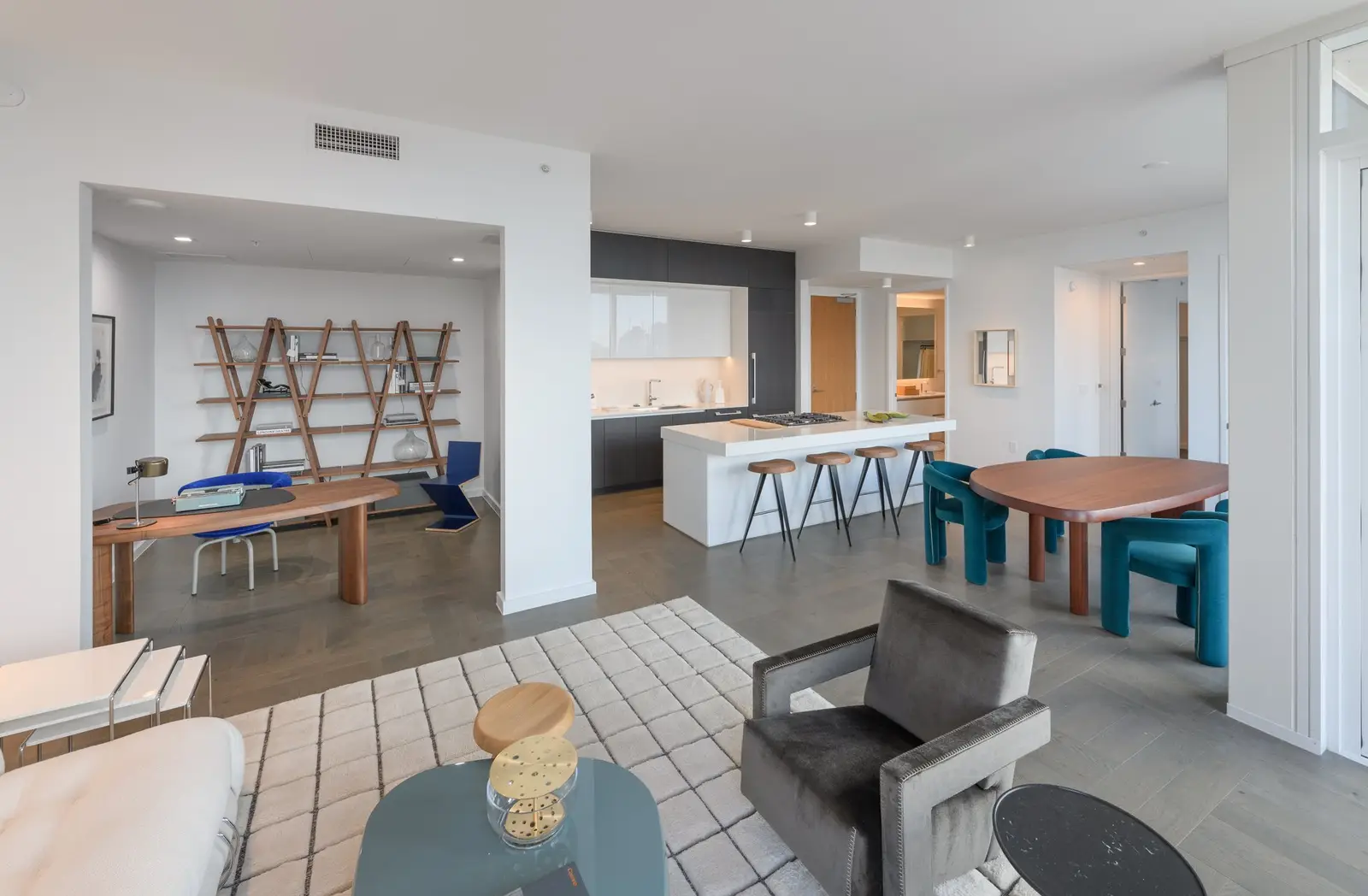 Linden Residences living and dining area with a white island kitchen and a dark cabinet wall