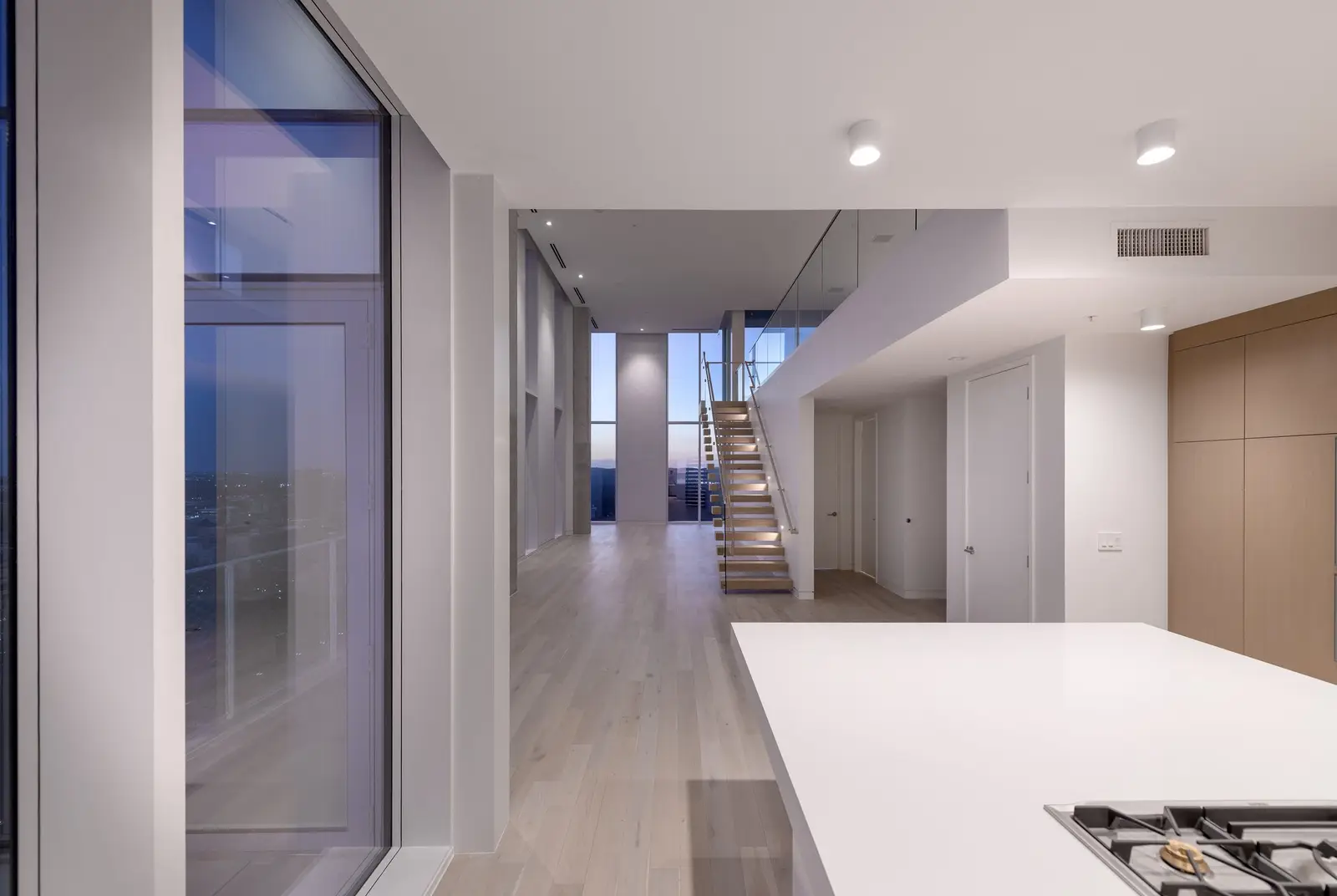 Linden Residences hallway and kitchen island with stairs and tall windows