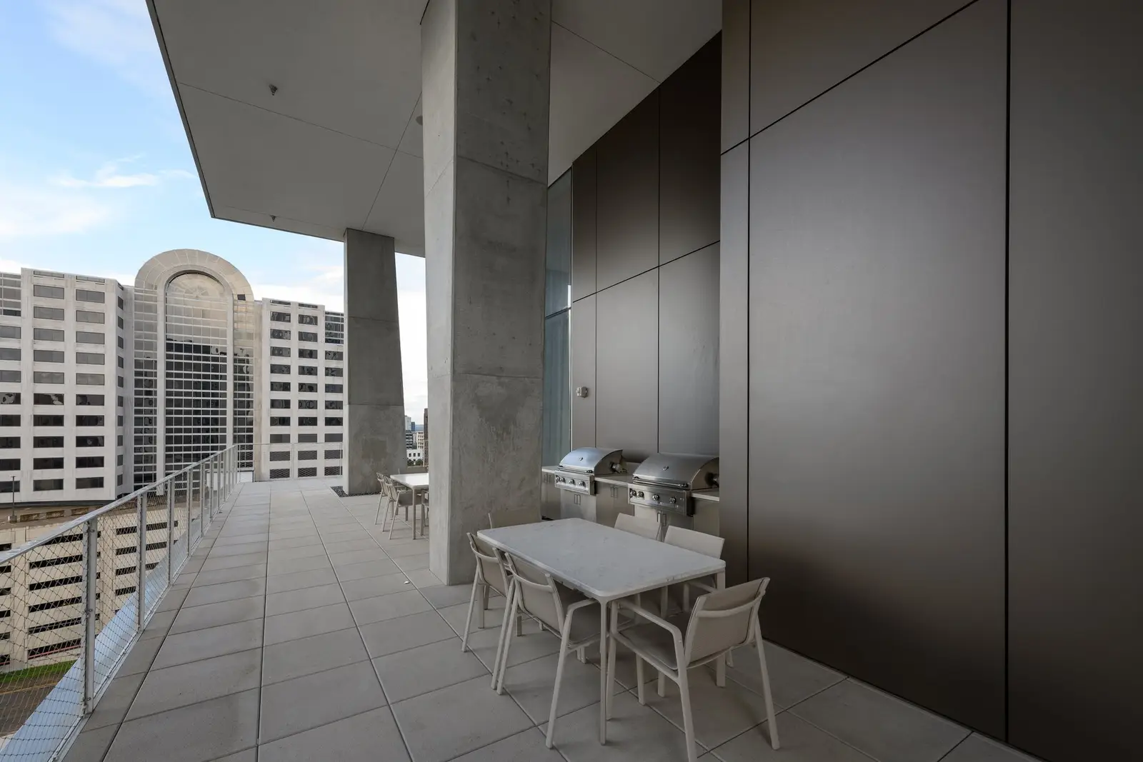 Linden Residences terrace with an outdoor dining table and grill under a roof overhang