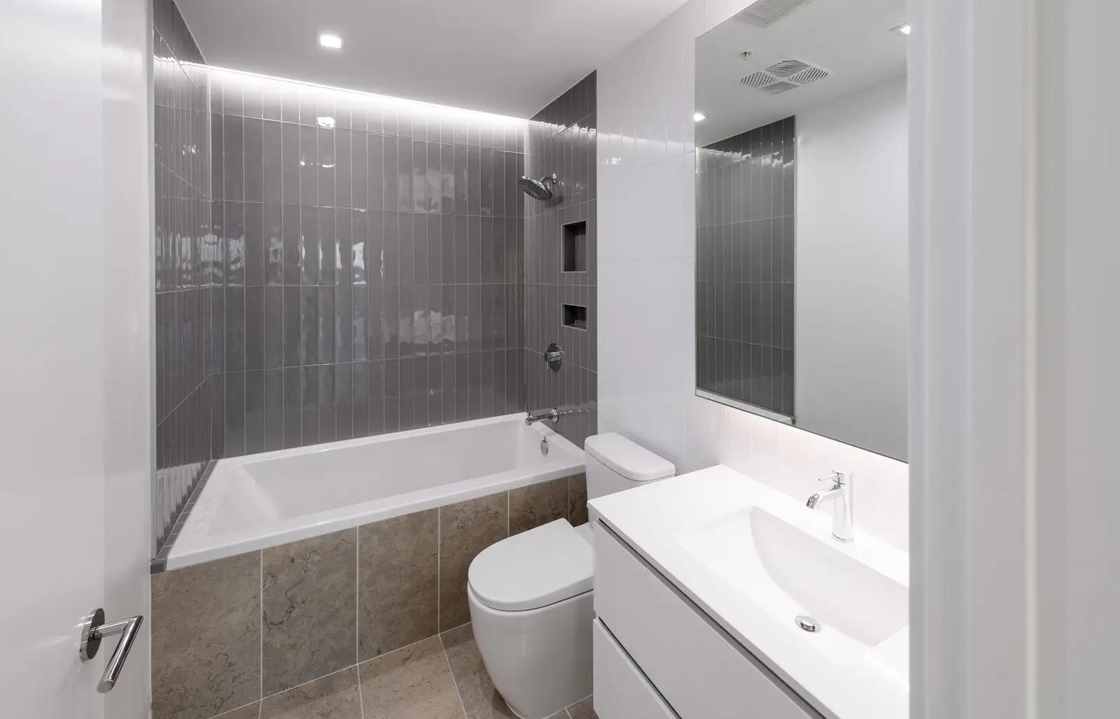 Linden Residences bathroom with gray tile tub surround and a white vanity