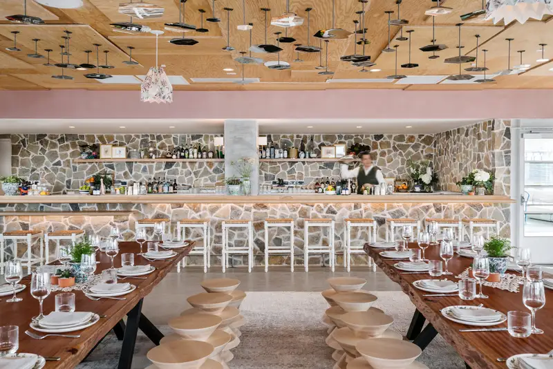 Line Hotel restaurant with a stone back wall, long wood tables and a wood ceiling