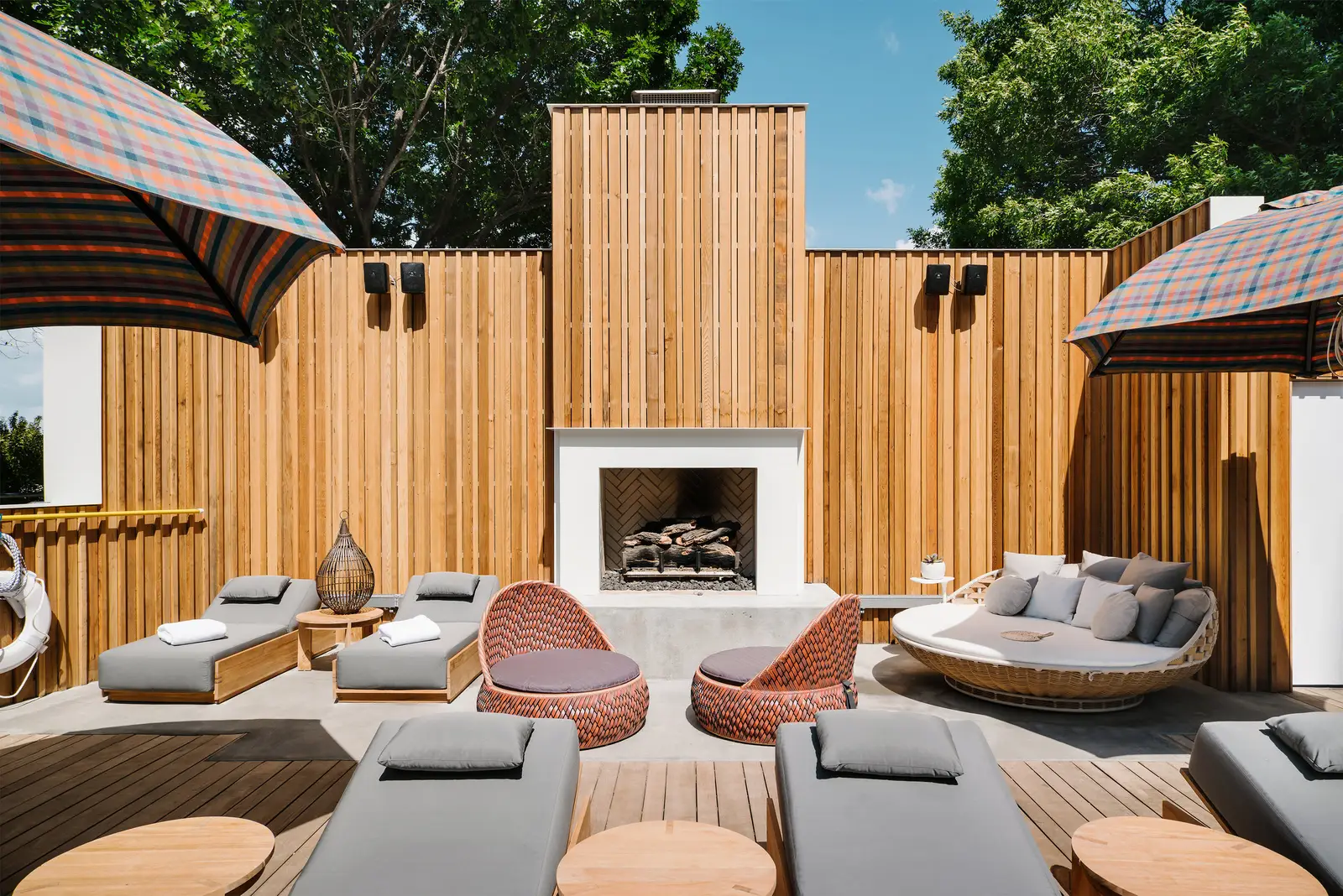 Line Hotel pool terrace with wood fence walls, a fireplace and lounge seating